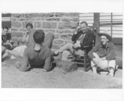 Blue Ridge campus scene at Black Mountain College. Although several BMC community members are pictured, the only ones identified are John Rice (sitting in the rocking chair) and student David Bailey (wearing a hat). Courtesy of Western Regional Archives.